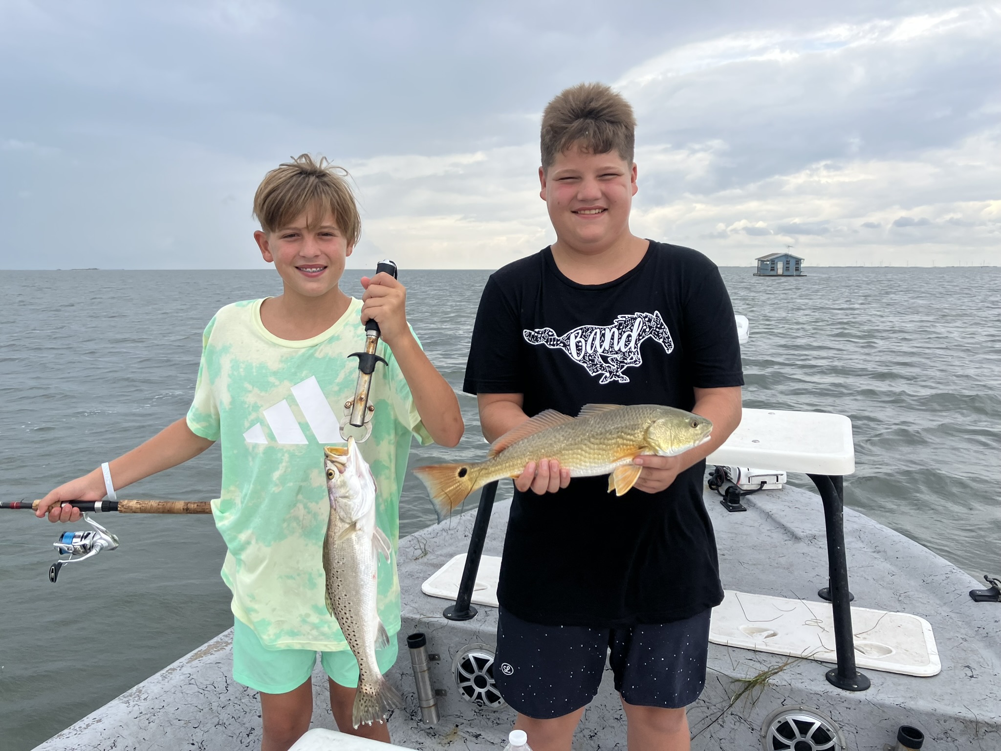 Two young anglers with a trout and redfish